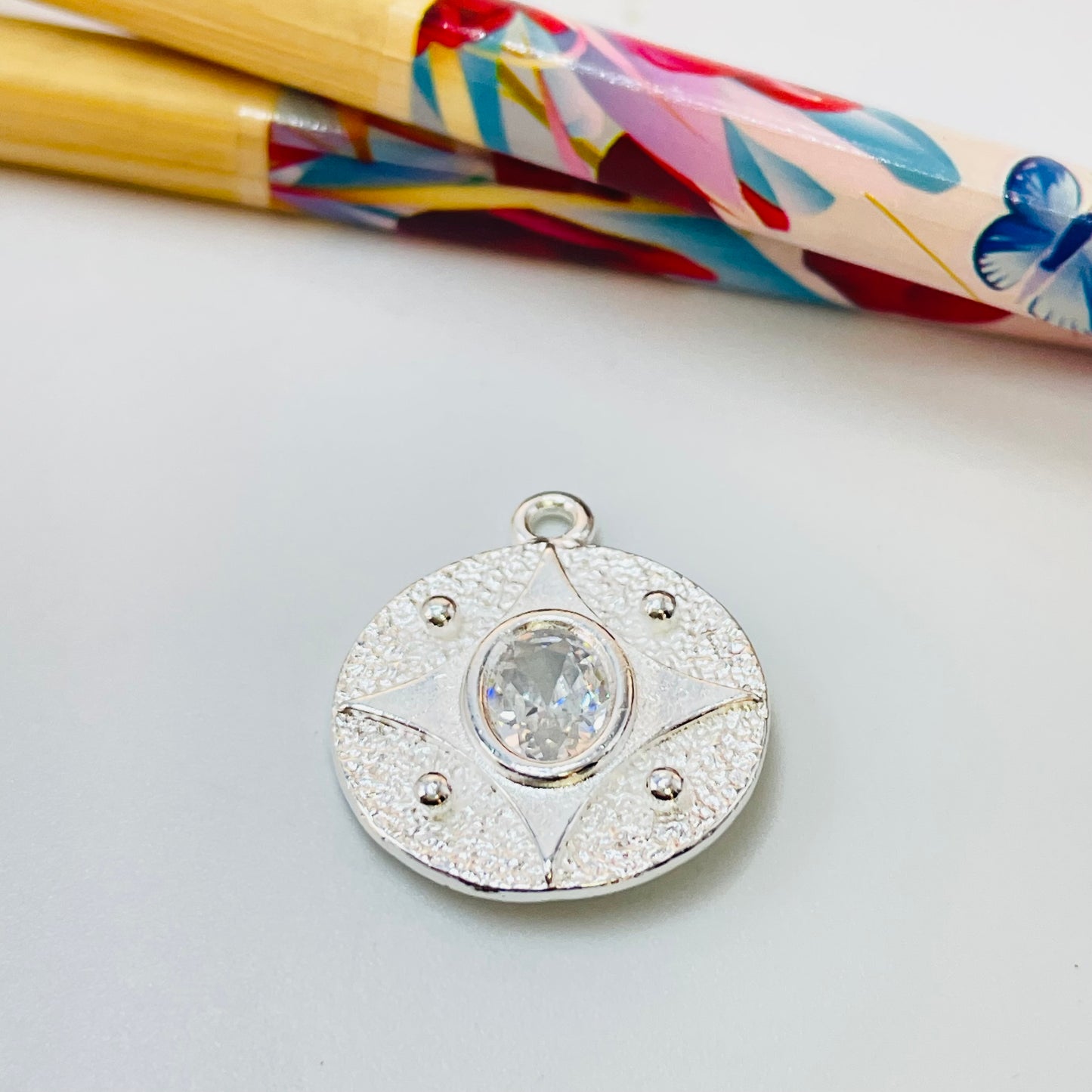 Joyas por Mayor Joyas Bañadas en Plata por Mayor Insumos para Joyas FP1146 Colgante Redondo Rústico Estrella 4 Puntas y Circón central Diá. 19 mm más argollita Espesor 1.5 mm Figura Baño Plata