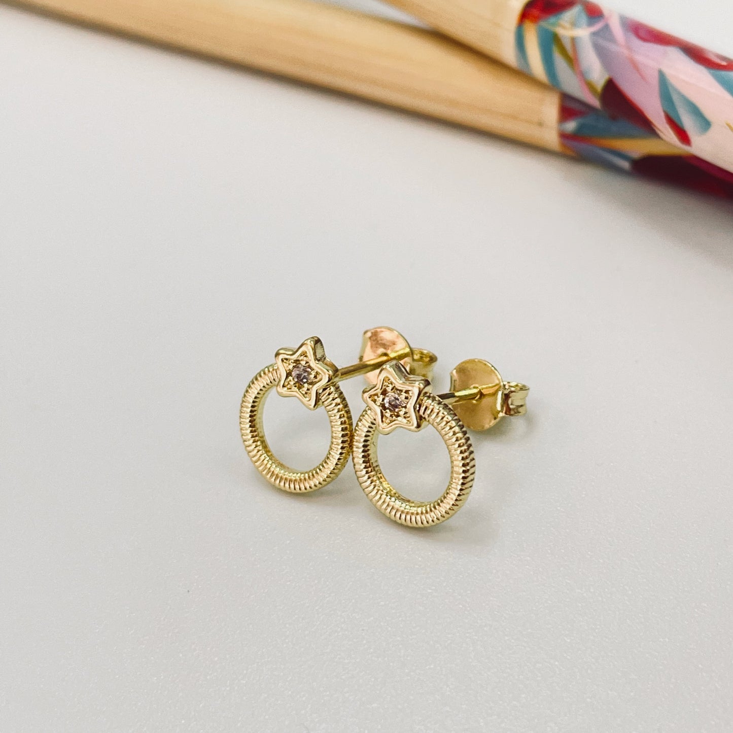 XO366 Aro Estrella con 1 circón 5 mm y argolla texturada Diá. 9.2 mm Tamaño Total 12.2 x 9 .2 mm Aro Baño Oro Aros Bañados hecho de Bronce Bañado en Oro 18K Joyas Bañadas en Oro
