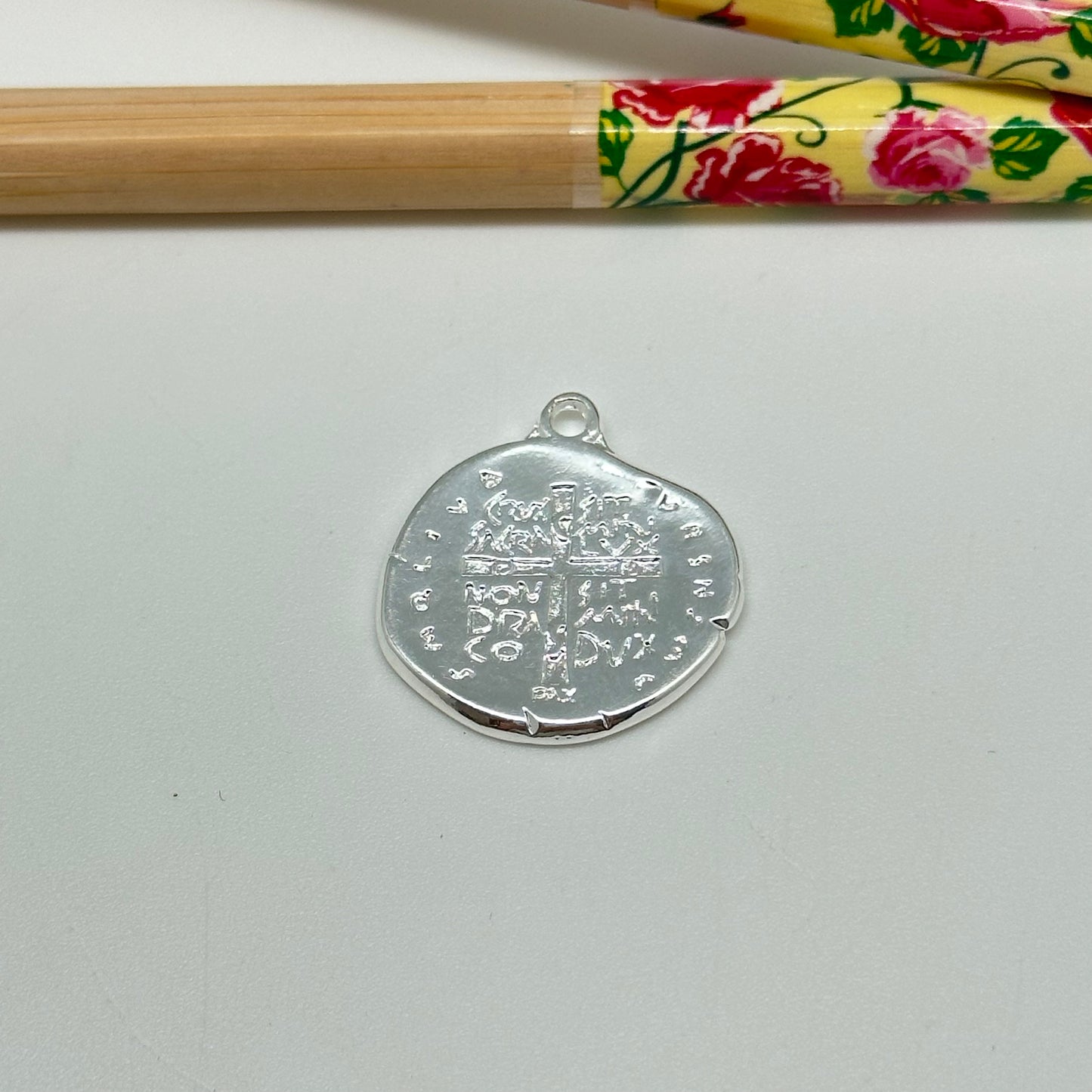 FP1033 Colgante medalla Cruz en relieve con inscripción borde irregular doble faz 18 x 20 mm mas argollita Figura Baño Plata