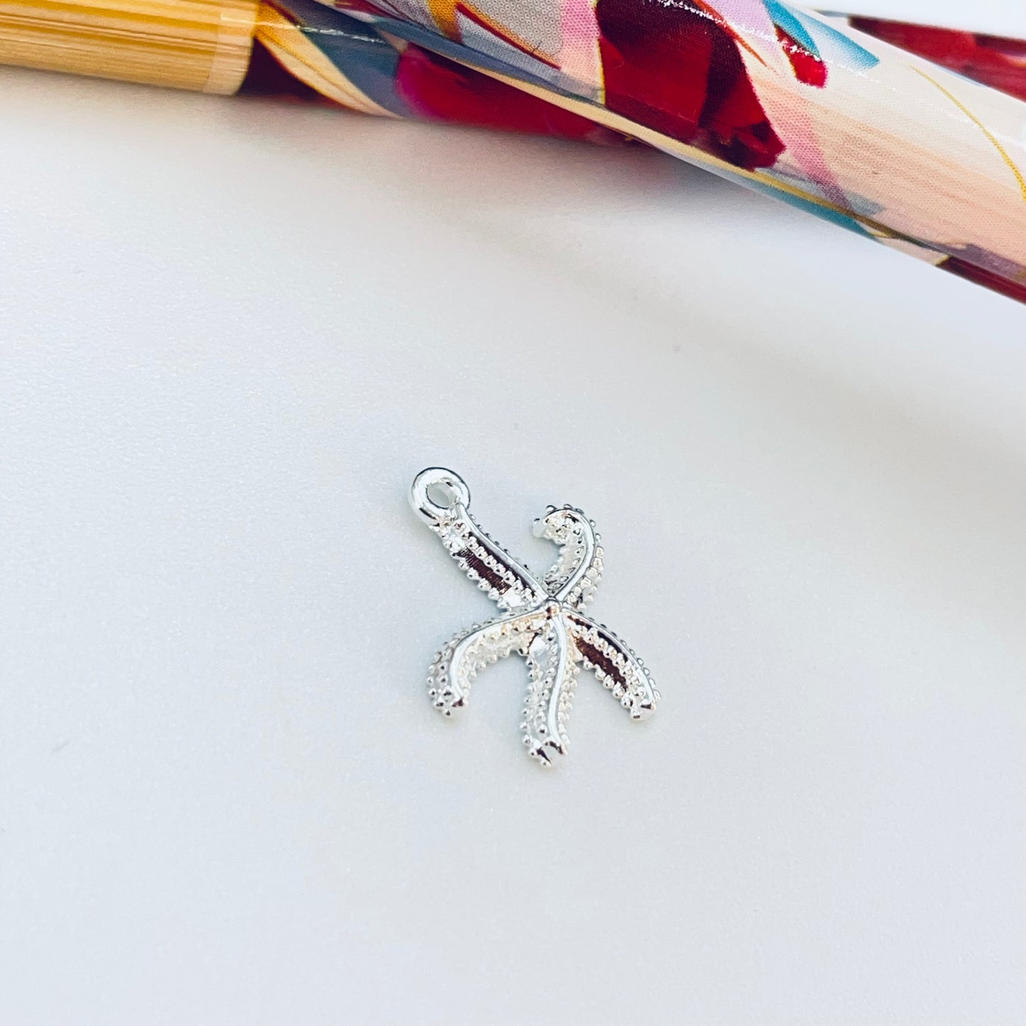 FP1229 Colgante Estrella de Mar Texturada 12 x 12 mm más argollita Espesor 1.8 mm Figura Baño Plata